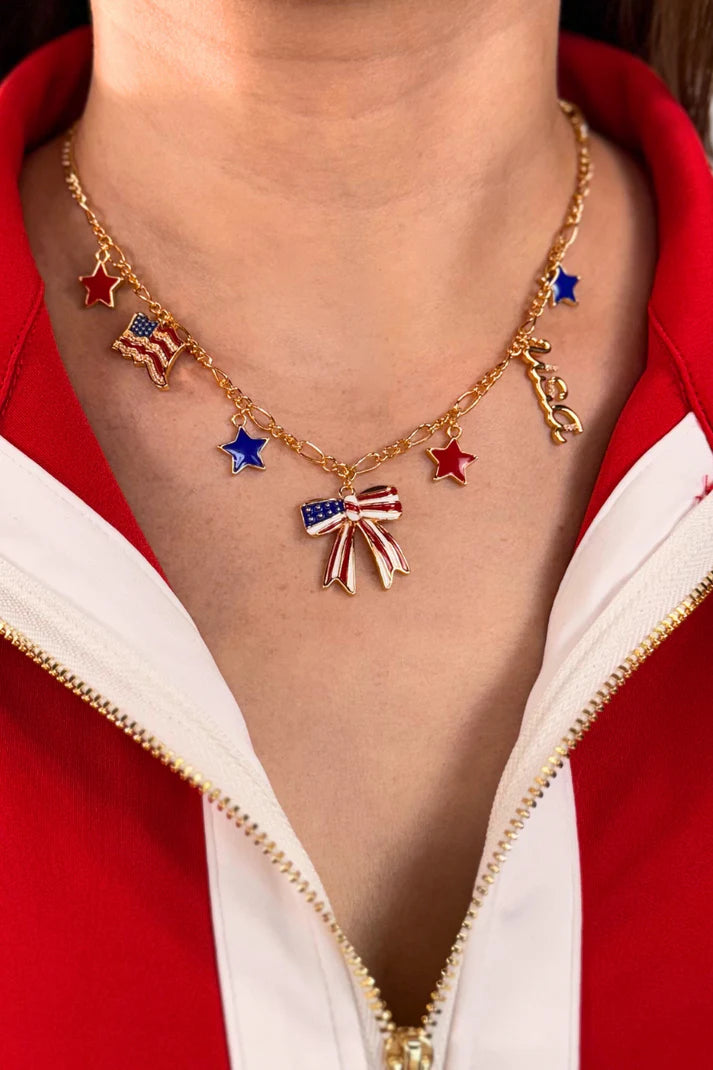 Jess Lea Gold charm necklace with red, white, blue stars, flags, and bow centerpiece on 16-inch chain.