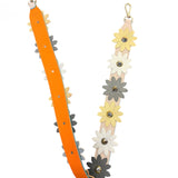 Flower in Metallic Purse Strap with leather daisy appliques, metal studs, and orange base.