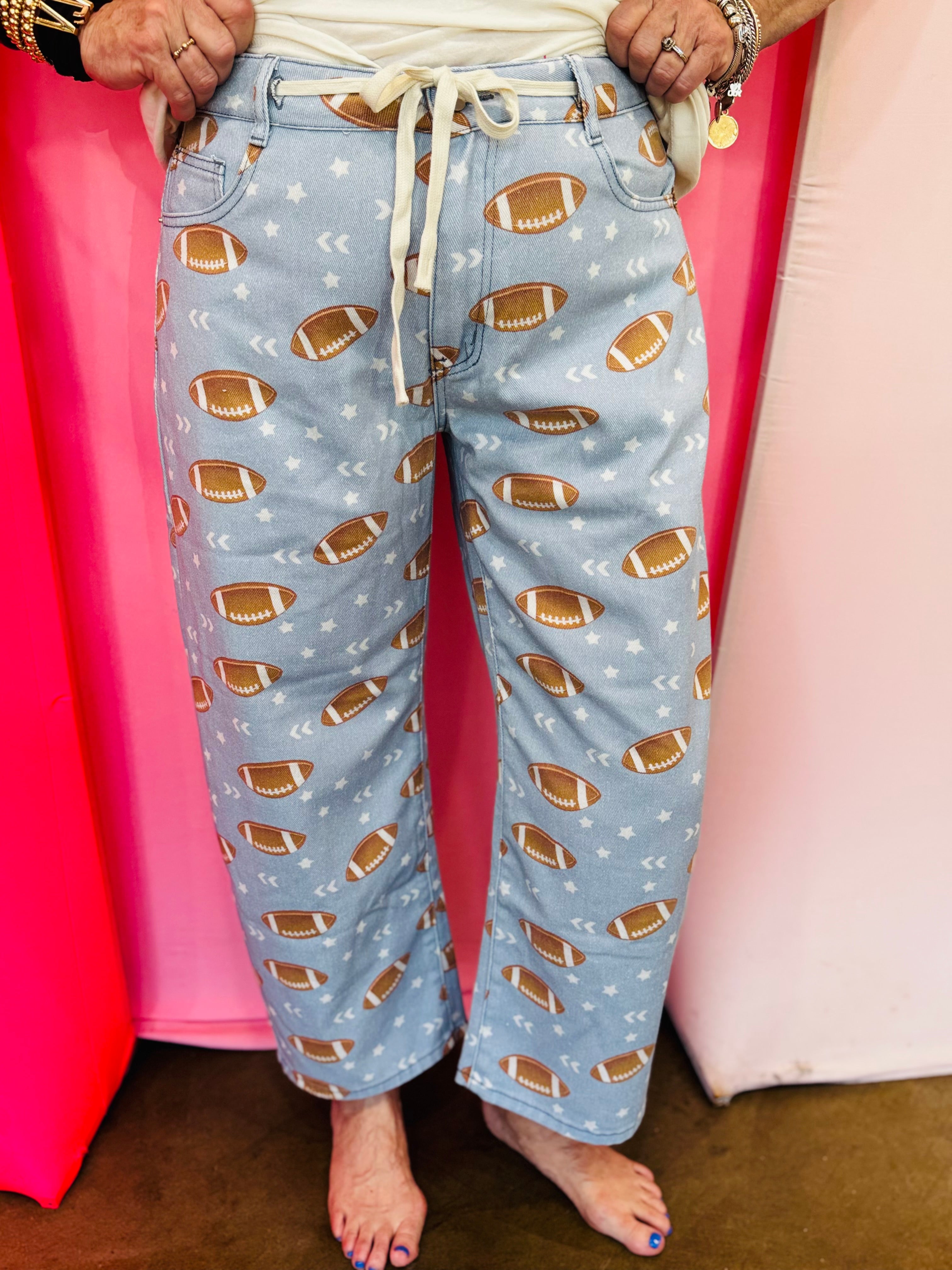 Football print barrel jogger pants with drawstring waist and star accents.