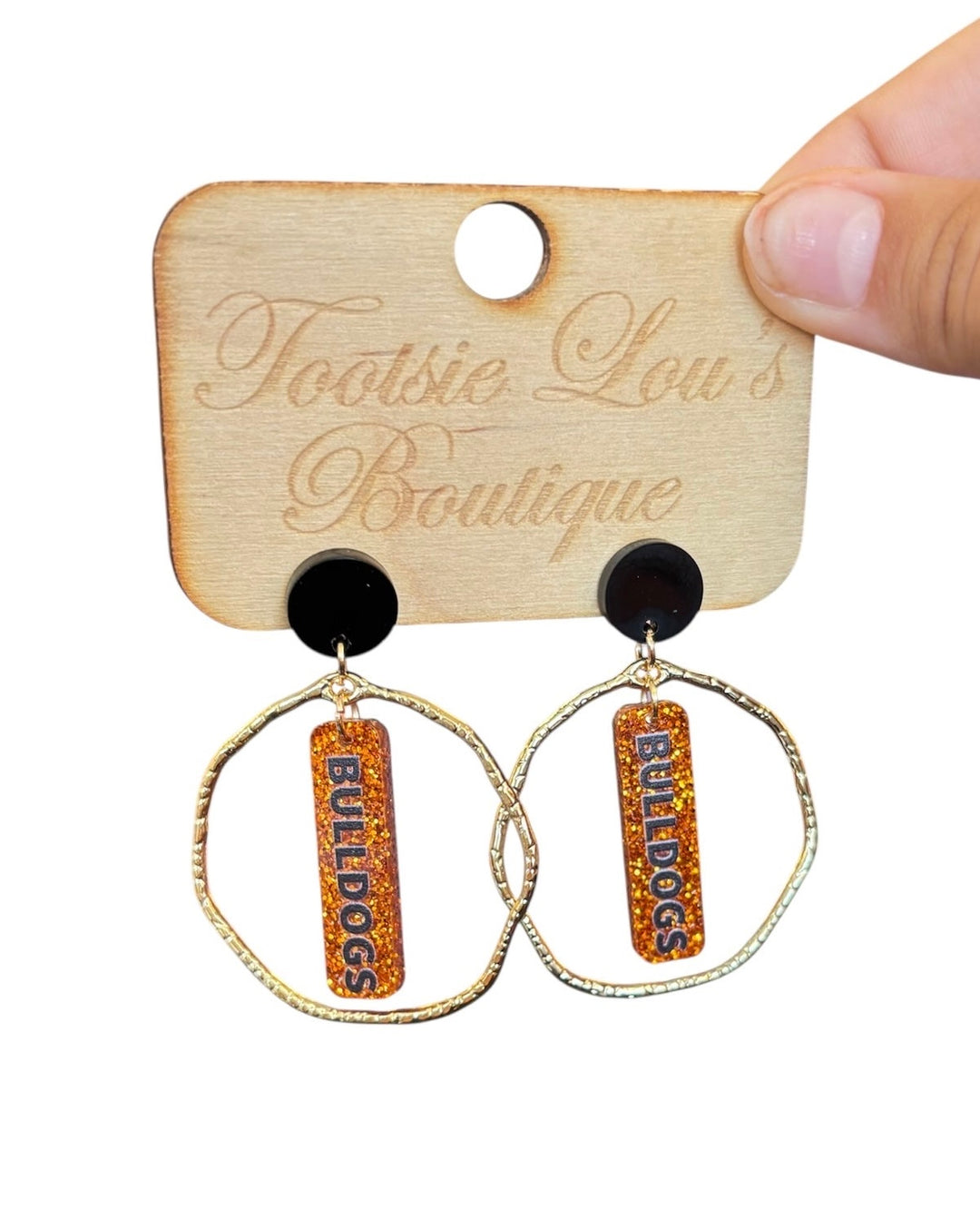 Gold hoops with orange glitter dangles and black writing that says Bulldogs set on black stud.