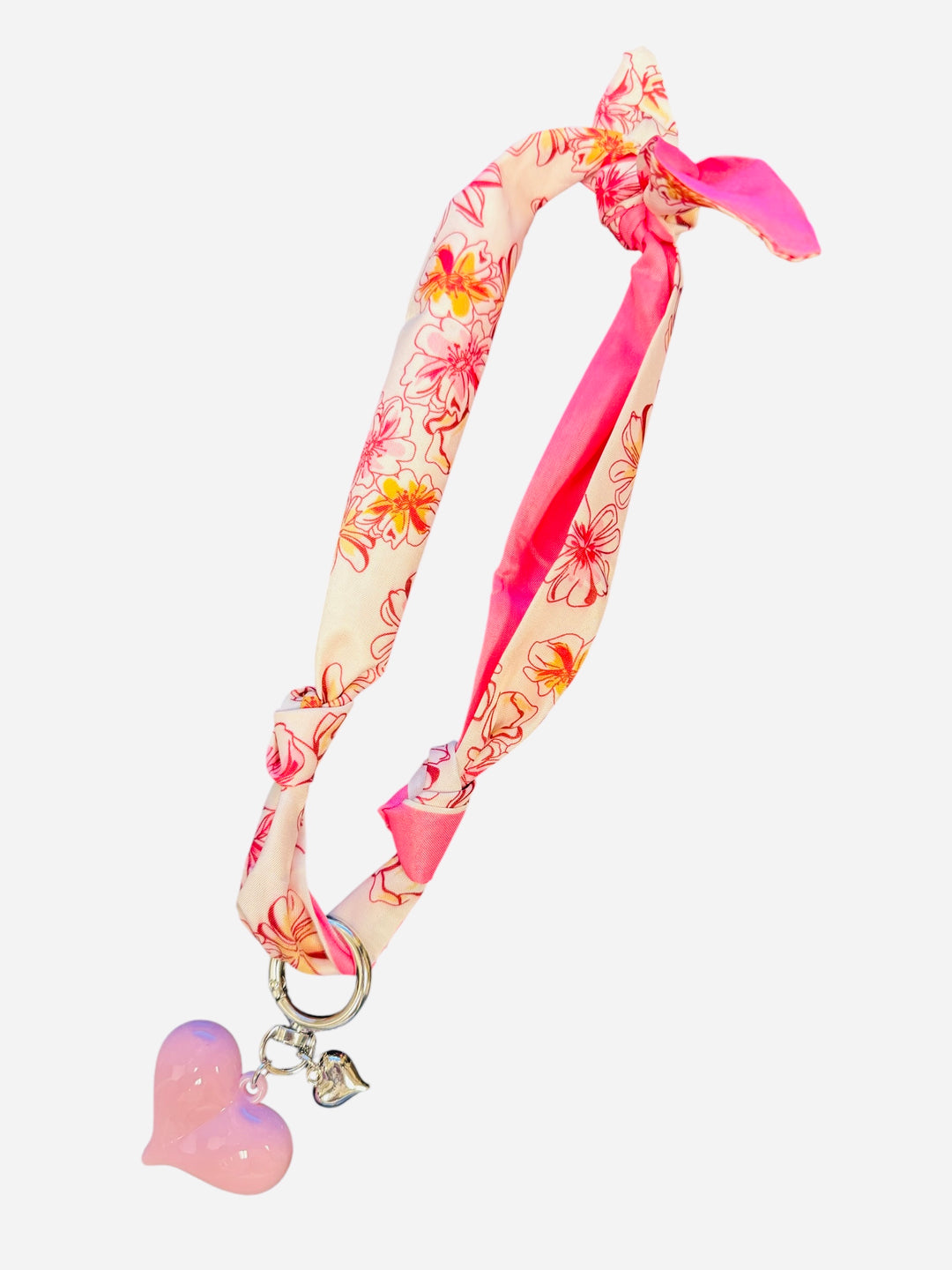 Pink and ivory floral scarf necklace with puffy pink heart charm and silver heart charm, tied in a stylish knot and designed to be worn as a necklace, bracelet, or accessory.