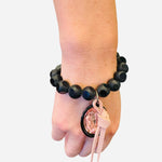 Large black and pastel pink beaded bracelet with oversized pastel pink rhinestone charm and leather accent