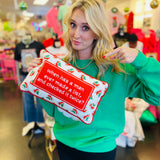 Red holiday needlepoint pillow with quote and festive holly border.