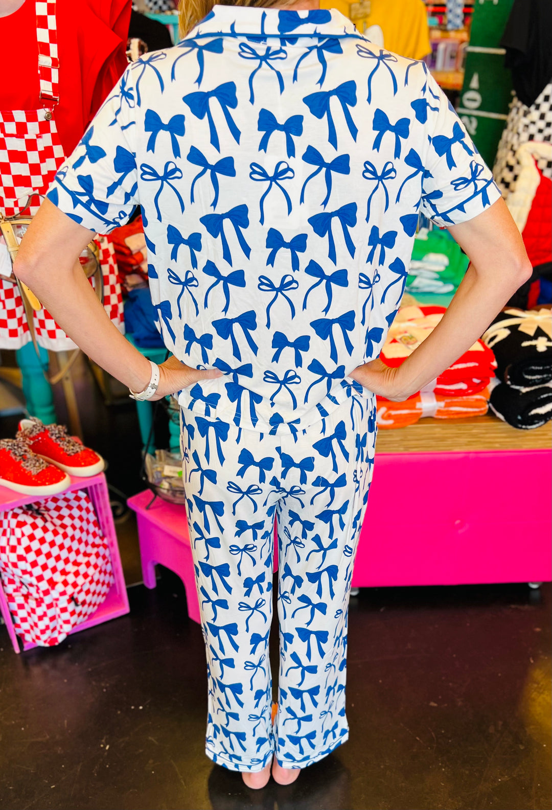 White pajama set with soft blue bow print, featuring a relaxed-fit short-sleeve top and matching pants made from lightweight, stretchy fabric for cozy comfort.