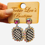 Black and white checkered glitter acrylic earrings with iridescent rhinestones and oversized stud tops.