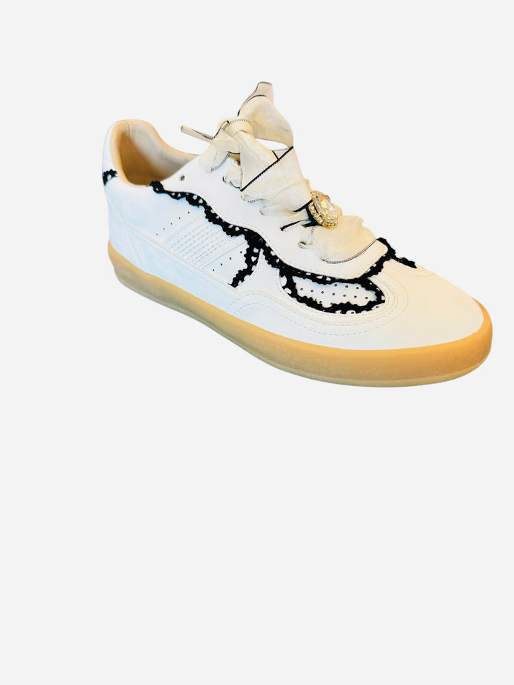 White low-top sneakers with vegan leather upper, delicate lace trim, lace-up closure, and round toe.