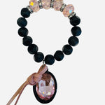 Large black and pastel pink beaded bracelet with oversized pastel pink rhinestone charm and leather accent