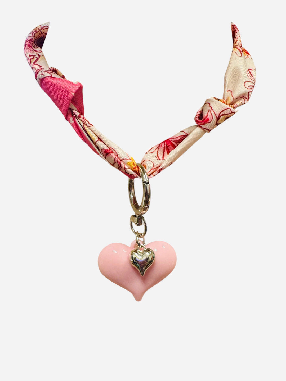 Pink and ivory floral scarf necklace with puffy pink heart charm and silver heart charm, tied in a stylish knot and designed to be worn as a necklace, bracelet, or accessory.
