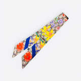 Silky floral twilly scarf with neutral base and vibrant yellow, coral, blue, and lavender blooms.