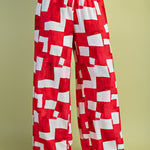 Red and white geometric wide-leg pants with elastic drawstring waist in lightweight rayon-blend fabric.