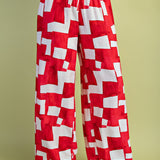 Red and white geometric wide-leg pants with elastic drawstring waist in lightweight rayon-blend fabric.