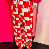 Red and white geometric wide-leg pants with elastic drawstring waist in lightweight rayon-blend fabric.