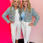 Denim jacket covered in colorful gemstones with pearl embellished collar and cuffs.