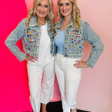 Denim jacket covered in colorful gemstones with pearl embellished collar and cuffs.