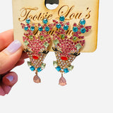 Rhinestone reindeer earrings with multicolor gems, fluttery lashes, red nose, and teardrop accent.