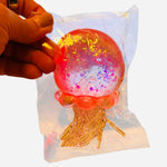 Glitter jellyfish squishy stress toy in assorted colors.