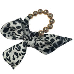 Oversized gold bead stretch bracelet with black and cream animal print scarf.