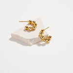 Gold-tone stainless steel beaded hoop earrings with cubic zirconia sparkle, modern textured design.