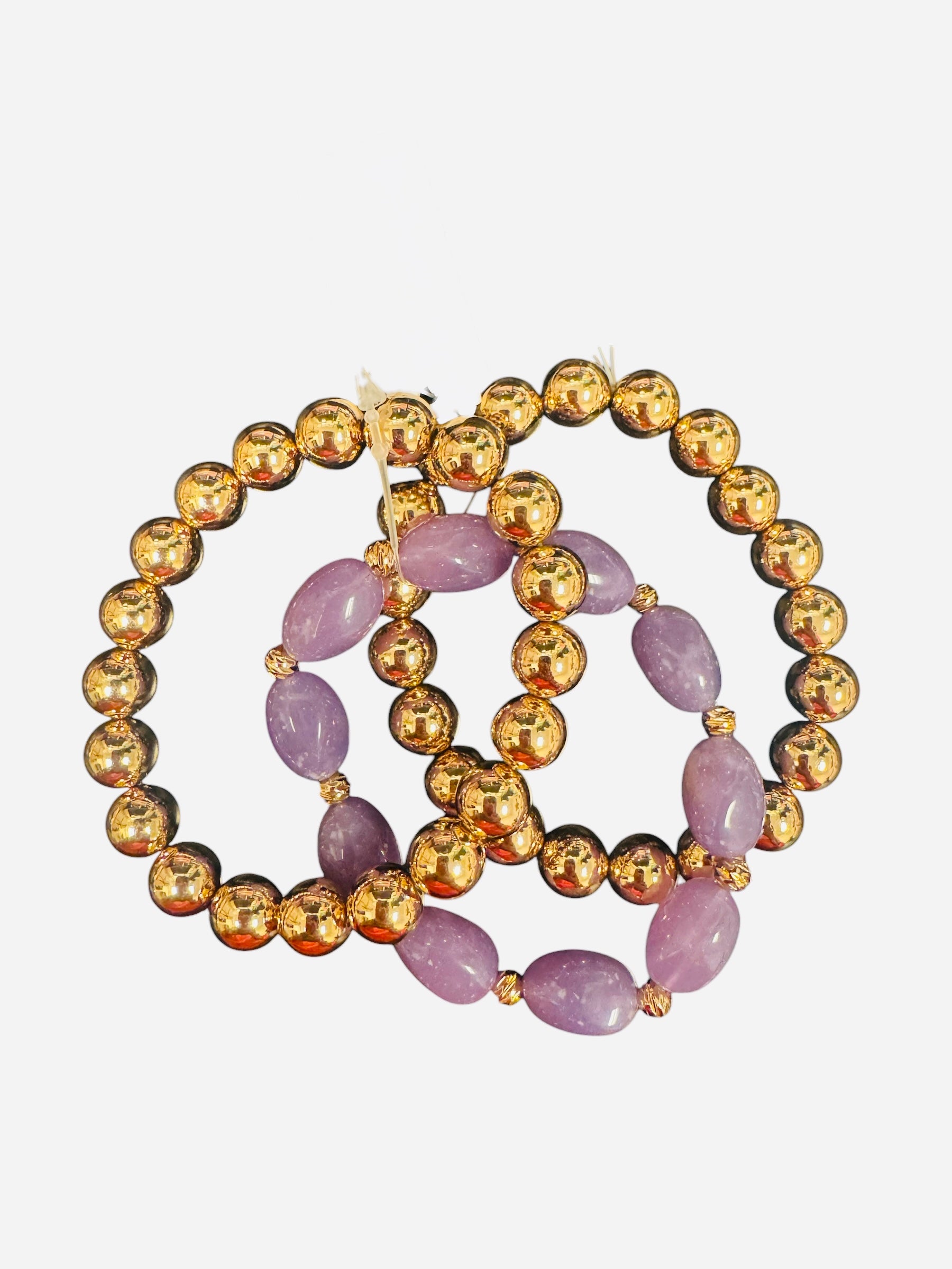 Three-piece gold and lavender beaded bracelet stack with water-resistant design.