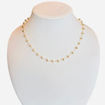 Gold-toned necklace with round beads and magnetic clasp on a delicate chain.
