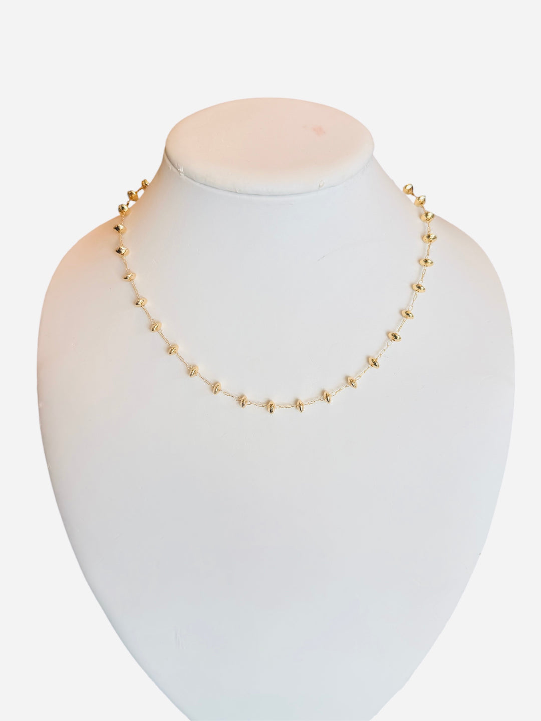 Gold-toned necklace with round beads and magnetic clasp on a delicate chain.
