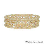 Set of five gold beaded textured stretch bracelets, water resistant and stylish for stacking.