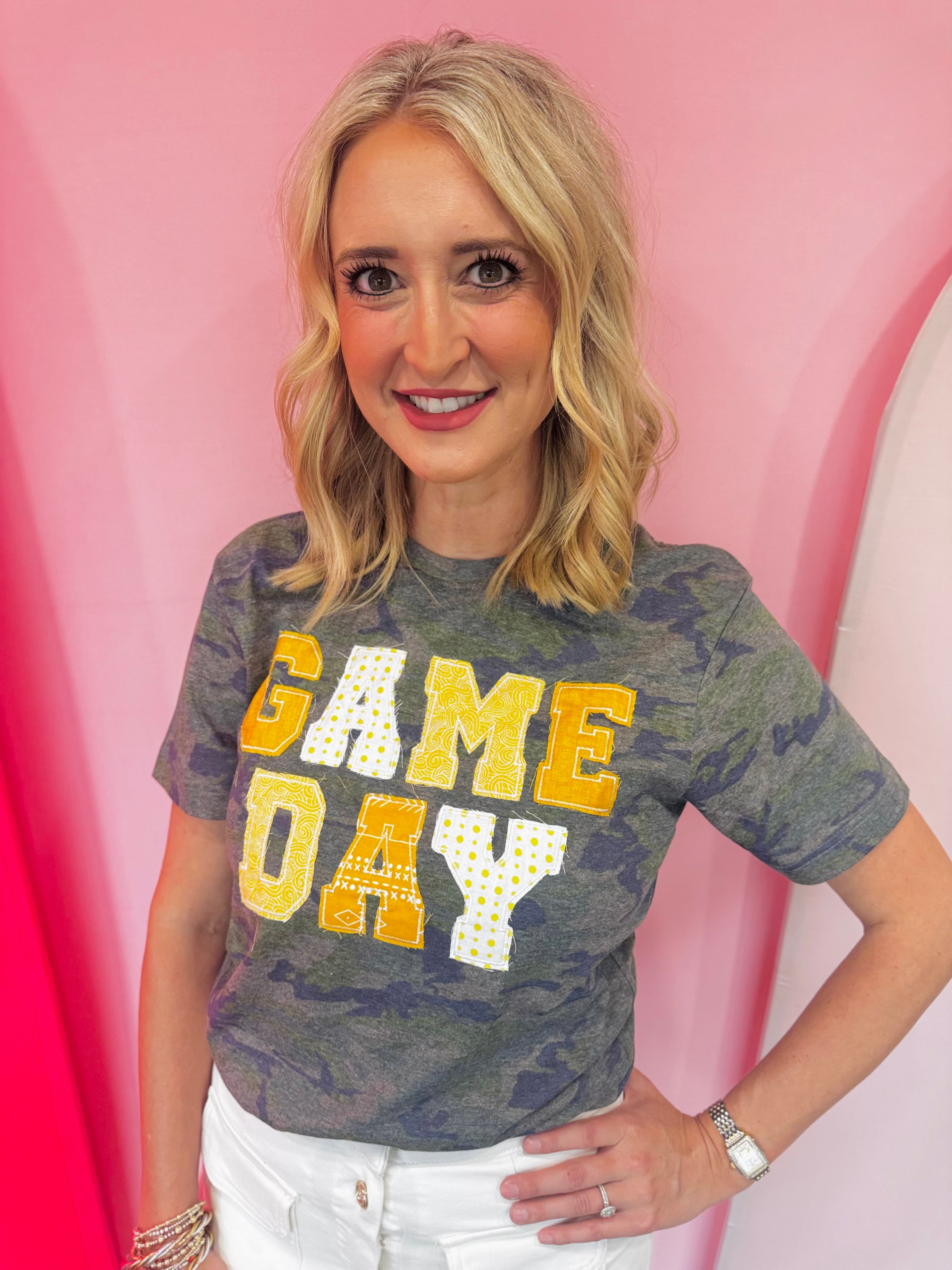 Gold Game Day tee with patchwork appliqué lettering and mixed gold print details.