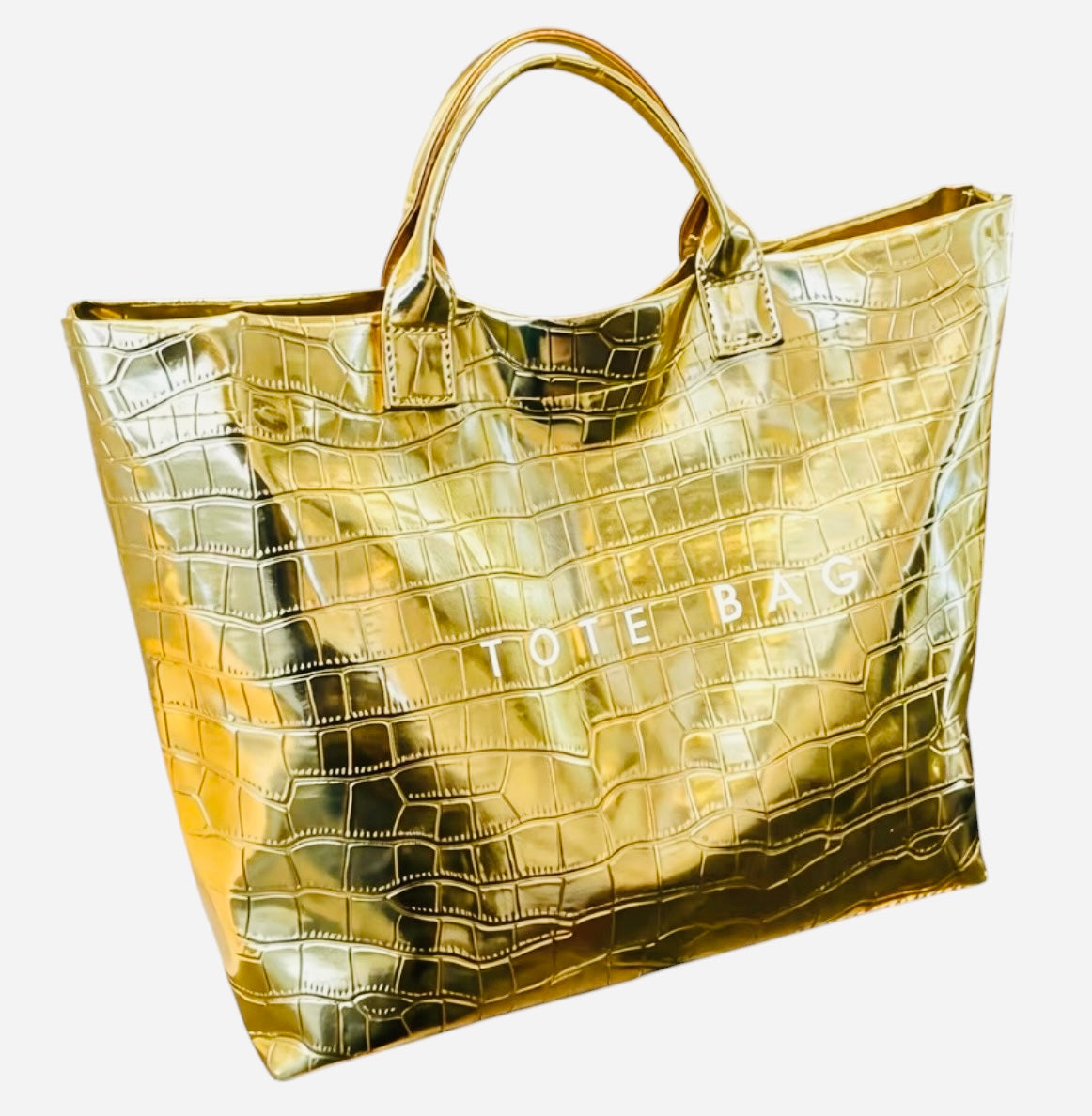Gold glossy crocodile embossed tote bag with spacious interior and hook-and-loop closure.