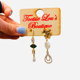 Gold mismatch earrings with crystal chain, pearl drop, and sunburst geometric details