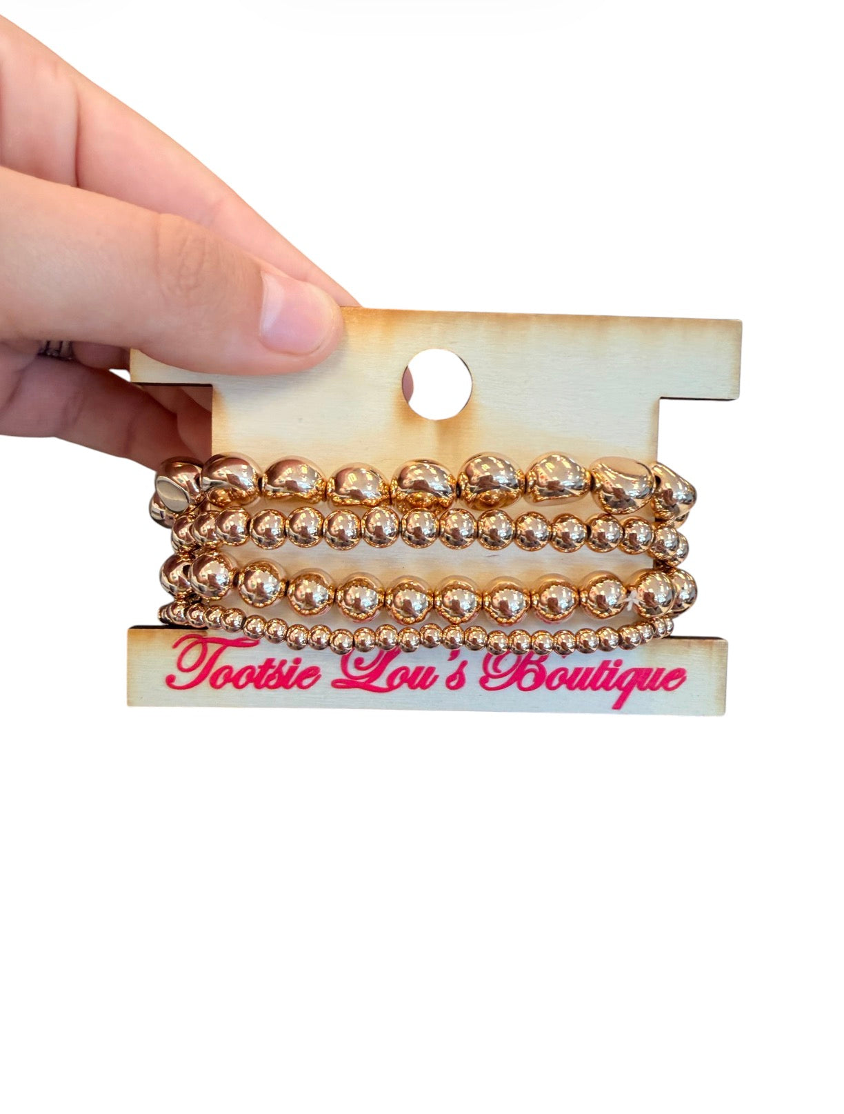 Water-resistant gold mixed bead stretch bracelet stack with four layered bracelets.