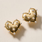 Matte heart stud earrings adorned with faux pearls for a bold, playful look.