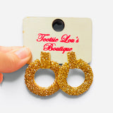 Oversized gold-tone hoop earrings with textured finish and sparkling rhinestone details.