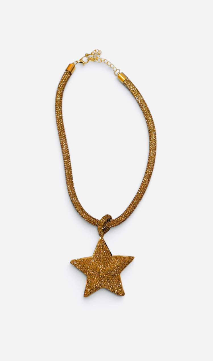 Gold necklace with oversized rhinestone star pendant and crystal-covered chain.