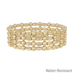 Gold textured oval and gold beaded set of four water resistant stretch bracelets stacked.