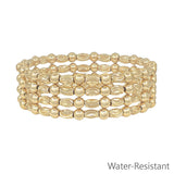 Gold textured oval and gold beaded set of four water resistant stretch bracelets stacked.