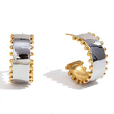 Chunky silver hoop earrings with gold interior and gold bead accents.