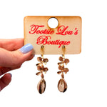 Gold floral drop earrings with layered blossoms and shell accent coastal style