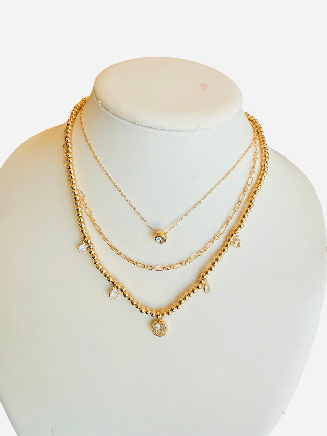 Layered gold necklace set with beads, chain links, and crystal charm pendants.