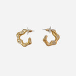 Matte gold wave-shaped hoops accented with tiny sparkling crystals.