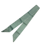 Dark green twilly scarf with white polka dots styled on neck