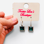 Gold-tone hoops with faceted green square crystal drop earrings.