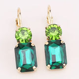 Emerald rhinestone earrings with green stud and gold settings.