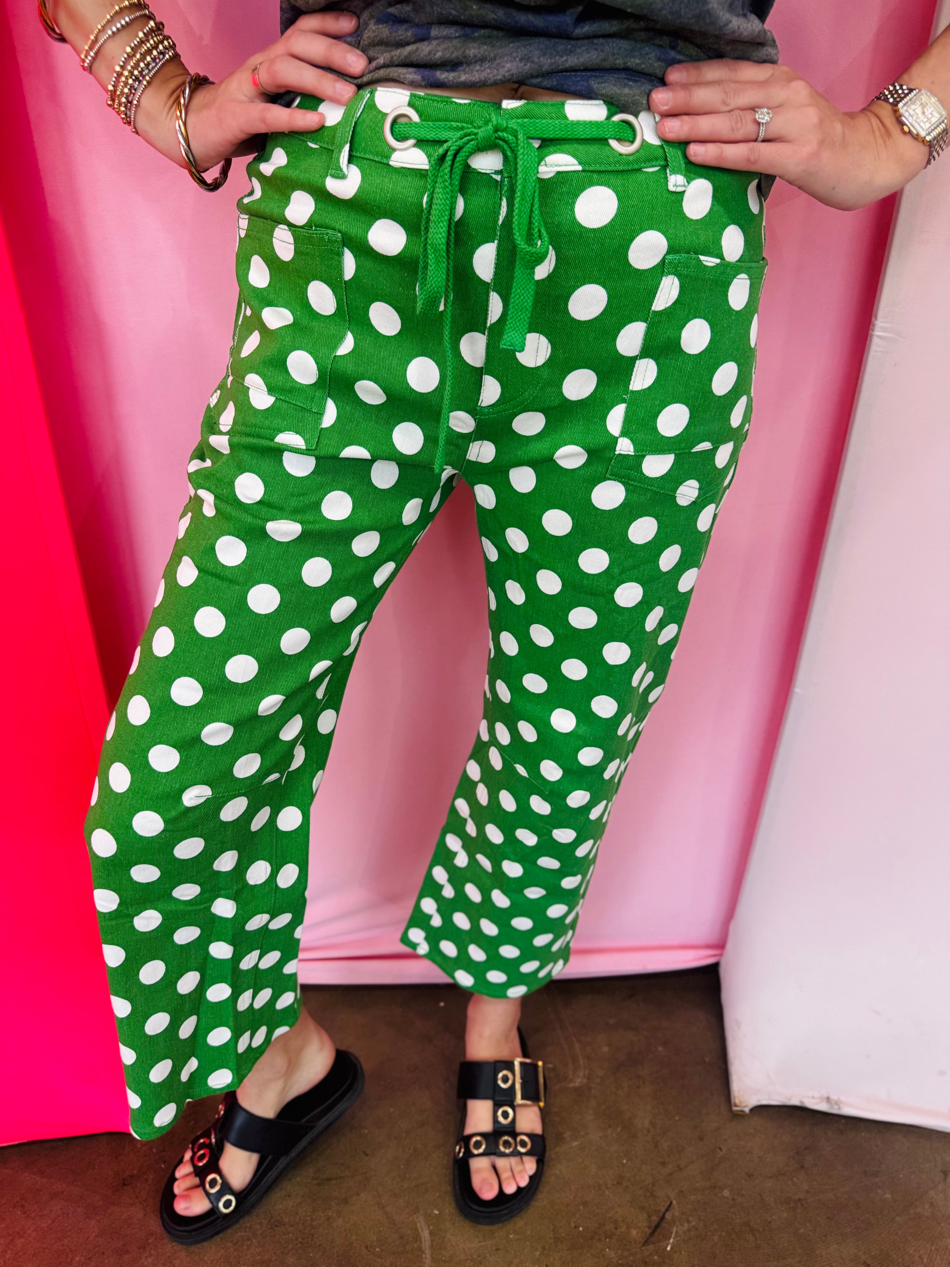 Green and white polka dot cropped barrel pants with drawstring waist and pockets.