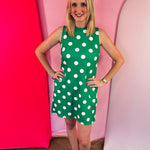Green sleeveless polka dot dress with oversized bow back detail and side pockets.