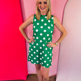 Green sleeveless polka dot dress with oversized bow back detail and side pockets.