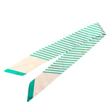 White twilly scarf with green diagonal stripes styled as purse tie
