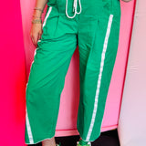 Kelly green cropped pants with white side stripes and drawstring waist.