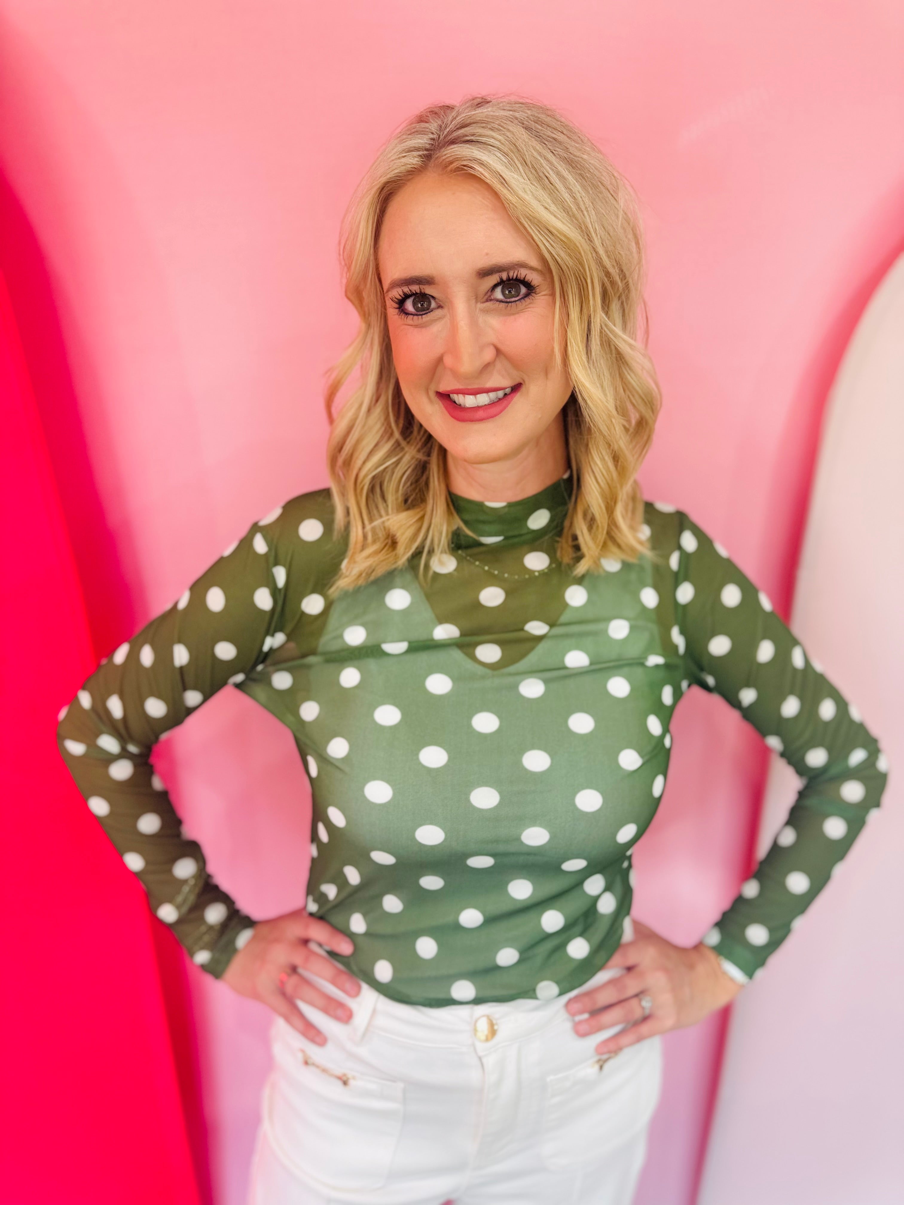 Green mesh top with white polka dots and mock neckline.