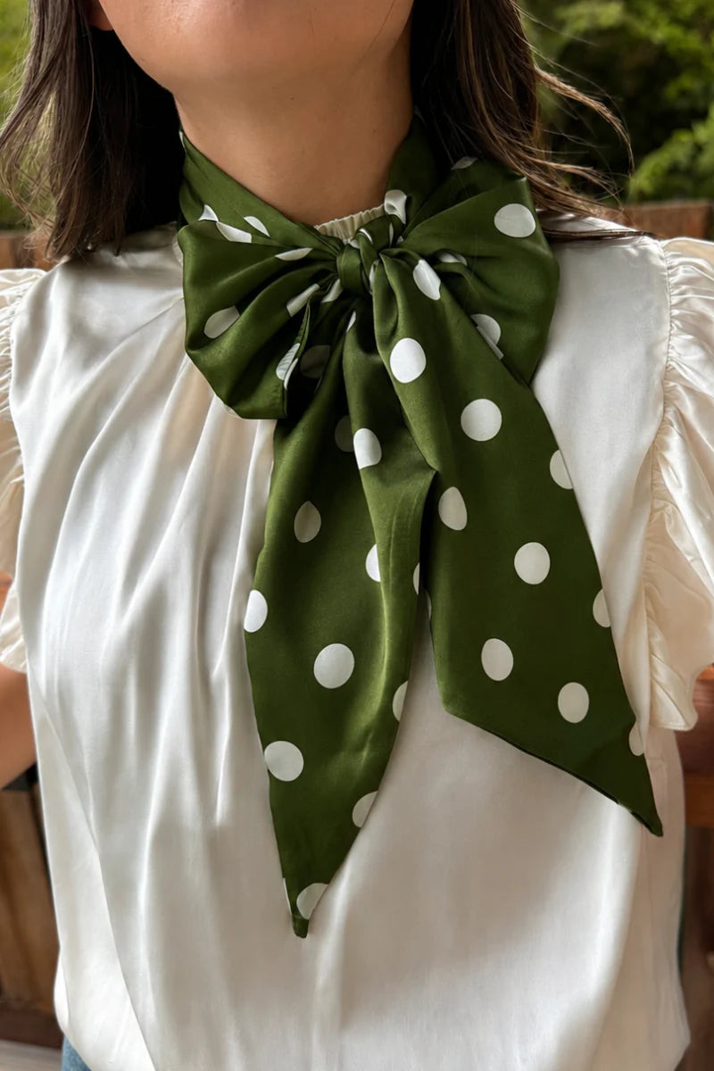 Green and white silky polka dot scarf with versatile styling options.