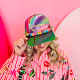 Tie-dye trucker hat with gold “Gumdrops & Gucci” embroidery, rainbow beaded brim, and mesh back.